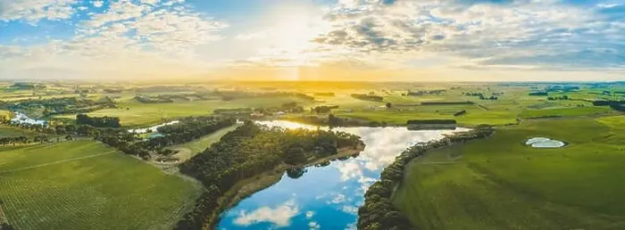 Framed Print : Sun setting over scenic Australian countryside grasslands and pastures with river passing through - aerial panorama Framed Print : Sun setting over scenic Australian countryside grasslands and pastures with river passing through - aerial panorama