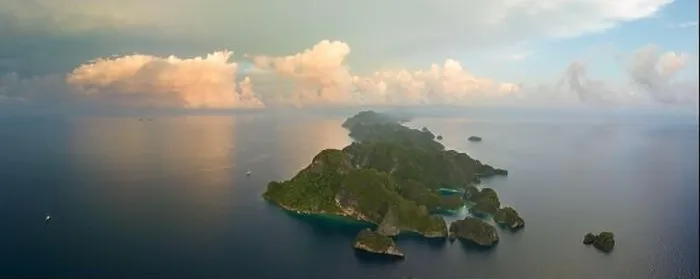Framed Print : Sunrise illuminates dramatic limestone islands that rise from Raja Ampat's beautiful seascape. This area is known for its high marine biodiversity