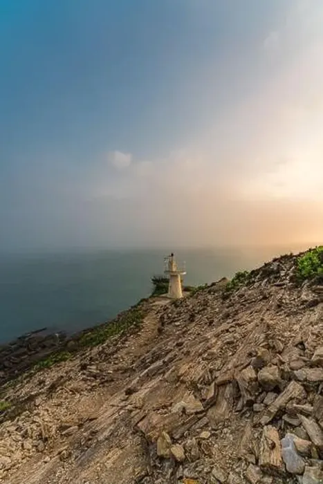 Framed Print : Sunrise by the sea with a lighthouse on the cliff
