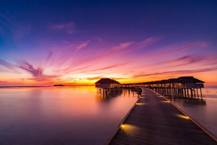 Framed Print : Sunset on Maldives island, luxury water villas resort and wooden pier. Beautiful sky and clouds and beach background for summer vacation holiday Framed Print : Sunset on Maldives island, luxury water villas resort and wooden pier. Beautiful sky and clouds and beach background for summer vacation holiday