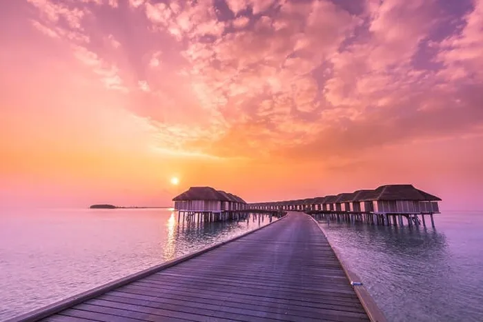 Framed Print : Sunset on Maldives island, luxury water villas resort and wooden pier. Beautiful sky and clouds and beach background for summer vacation holiday