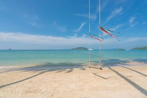 Swing hang from coconut palm tree over summer beach with clear water sea and wave with speed boat in background in Phuket, Thailand. Summer, Travel, V