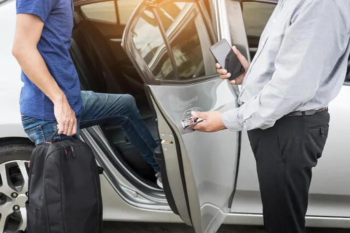 Framed Print : Taxi driver greeting his passengers with their luggage on the sidewalk of a modern city Framed Print : Taxi driver greeting his passengers with their luggage on the sidewalk of a modern city