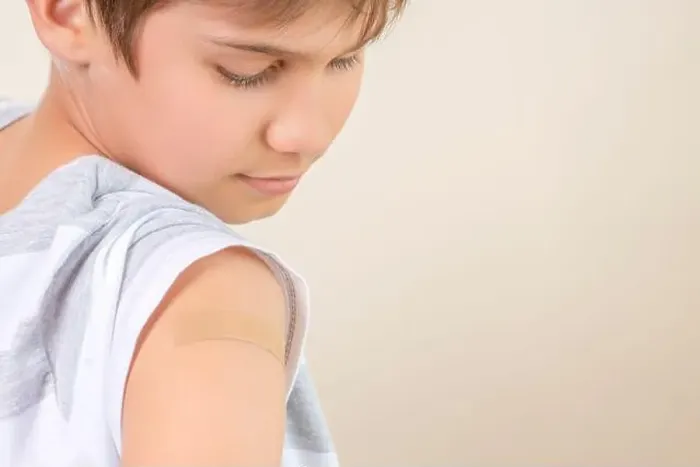 Framed Print : Teenage boy with adhesive bandage plaster on his arm after vaccination Framed Print : Teenage boy with adhesive bandage plaster on his arm after vaccination