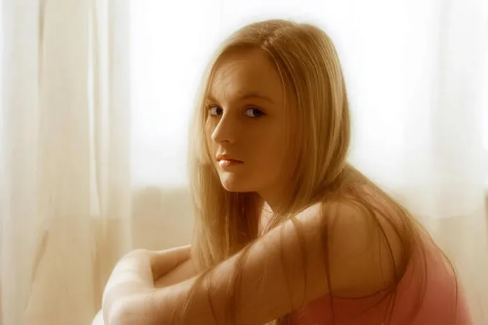 Framed Print : Teenage girl with blonde hair, sitting in front of net curtains in window Framed Print : Teenage girl with blonde hair, sitting in front of net curtains in window