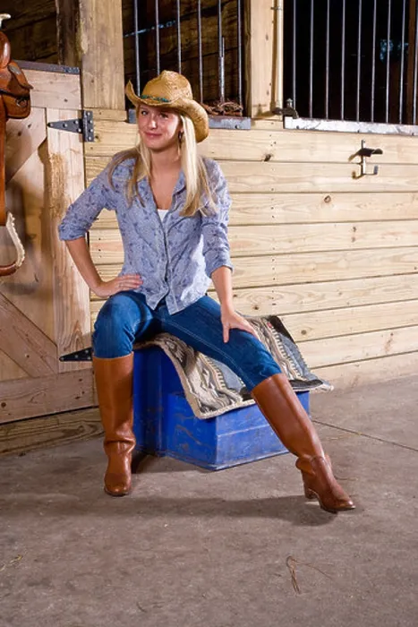 Framed Print : Teenage girl in stable with saddle wearing cowboy hat and boots Framed Print : Teenage girl in stable with saddle wearing cowboy hat and boots