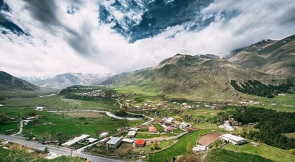Tkarsheti Village On Mountain Background In Kazbegi District, Mtskheta-Mtianeti Region, Georgia. Panoramic Landscape At Spring Or Summer Season