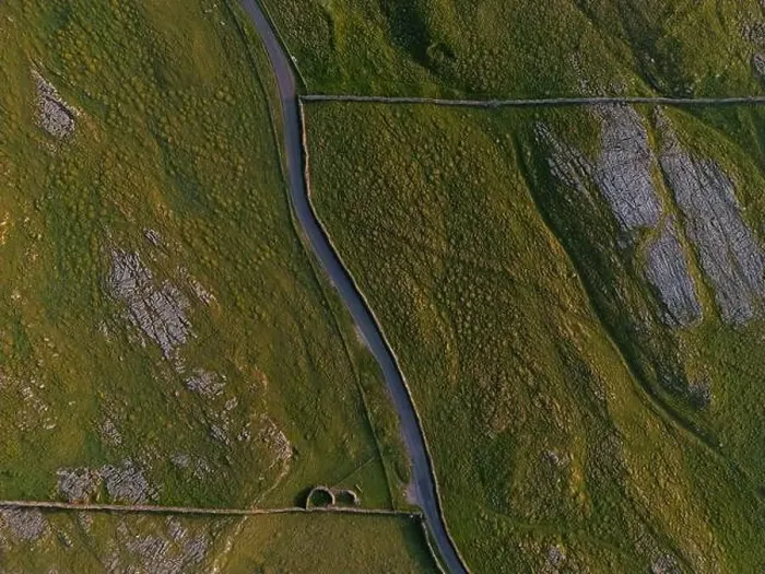 Framed Print : A top-down shot capturing a serpentine road meandering through a rugged, natural landscape with textured terrain