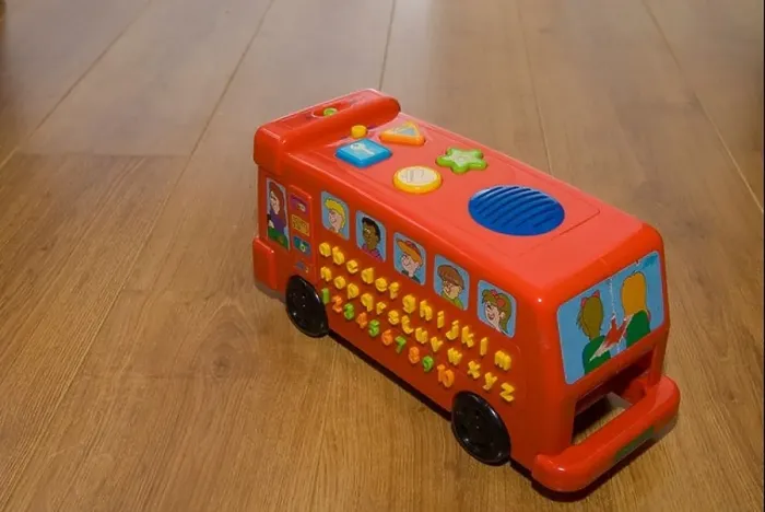 Framed Print : Toy red bus on a wooden laminate floor Framed Print : Toy red bus on a wooden laminate floor