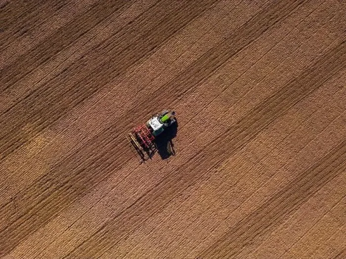 Framed Print : A tractor with plow on a field plowing from the ground directly from above with drone Framed Print : A tractor with plow on a field plowing from the ground directly from above with drone
