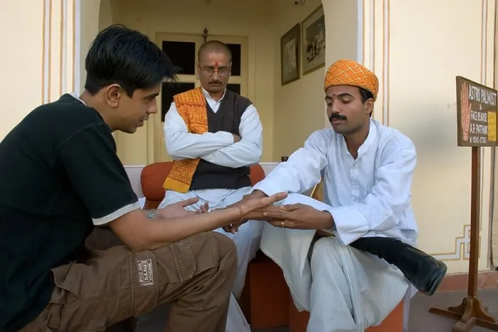 Framed Print : Traditional Indian astrologers (or palmists) reading into a young lad's future Framed Print : Traditional Indian astrologers (or palmists) reading into a young lad's future
