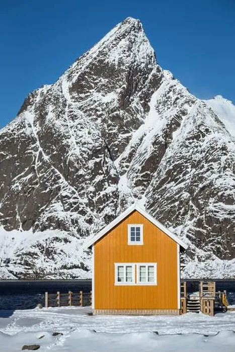 Framed Print : traditional norwegian wooden house rorbu to stand on the shore of the fjord and mountains in the distance Framed Print : traditional norwegian wooden house rorbu to stand on the shore of the fjord and mountains in the distance
