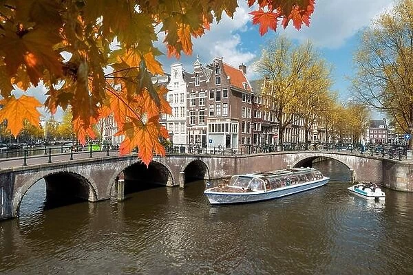 Traditional old houses on canal at fall day in Amsterdam, Netherlands at autumn season