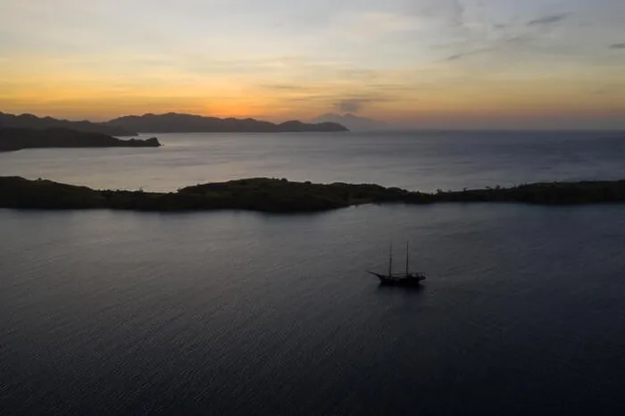 Framed Print : A traditional Pinisi schooner sails at sunset in Komodo National Park, Indonesia. This tropical area is known for its marine biodiversity