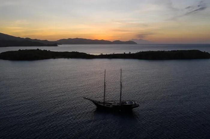 Framed Print : A traditional Pinisi schooner sails at sunset in Komodo National Park, Indonesia. This tropical area is known for its marine biodiversity