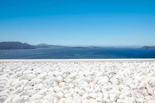 Traditional white architecture on Santorini island, Greece. White pebbles over blue sea view, idyllic calming travel landscape. Beautiful white decor