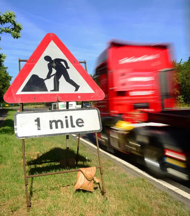 Framed Print : traffic passing roadworks warning sign one mile ahead on the A64 york yorkshire united kingdom Framed Print : traffic passing roadworks warning sign one mile ahead on the A64 york yorkshire united kingdom