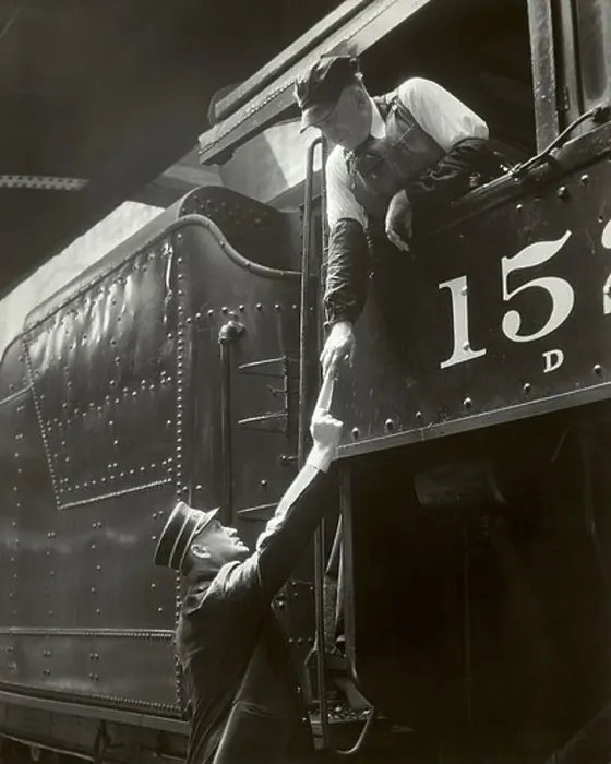Framed Print : Train conductor giving paper to train engineer