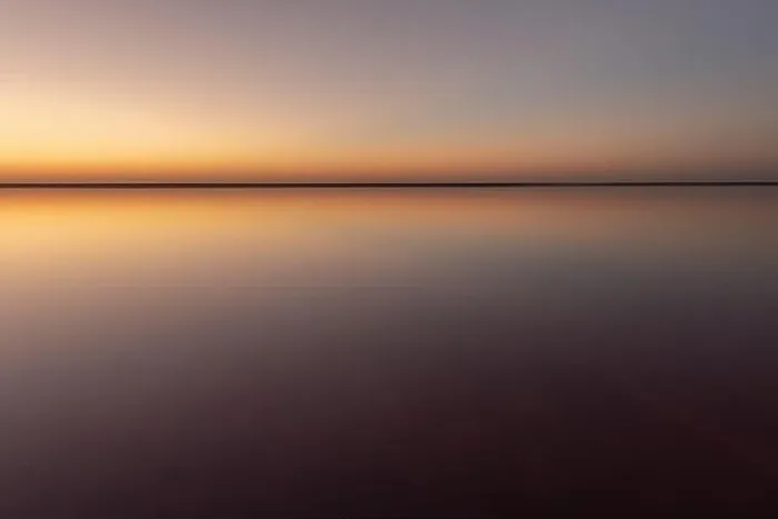 Framed Print : Tranquil minimalist landscape with smooth surface of the pink salt lake with calm water with horizon with clear sky in sunset time Framed Print : Tranquil minimalist landscape with smooth surface of the pink salt lake with calm water with horizon with clear sky in sunset time