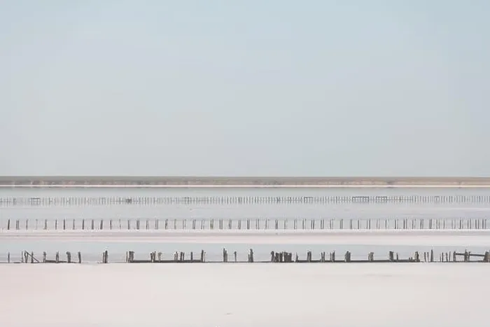 Framed Print : Tranquil minimalist landscape with smooth surface of the pink salt lake with wooden posts with clear sky in sunrise time Framed Print : Tranquil minimalist landscape with smooth surface of the pink salt lake with wooden posts with clear sky in sunrise time