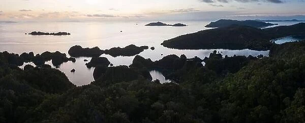 A tranquil sunrise greets the limestone islands in Raja Ampat, Indonesia. This region is thought to be the world's epicenter of marine biodiversity