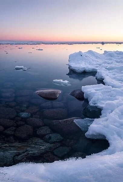 Tranquil winter sunset with melt sea and clean snow at beautiful peaceful evening in Finland