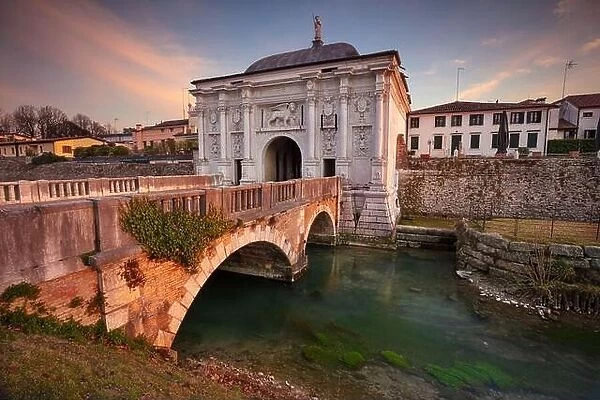 Treviso, Italy. Cityscape image of Treviso, Italy with gate to old city at sunset