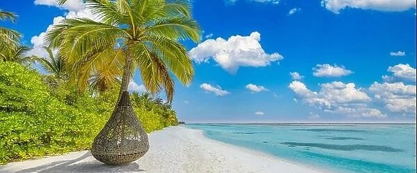 Tropical beach panoramic paradise. Summer island landscape, swing or hammock on palm tree. Sea sand sky as serene beach. Luxury beach scenic vacation