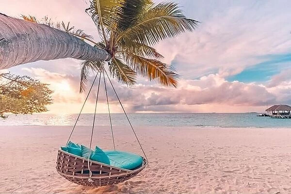 Tropical beach sunset panorama as summer landscape with beach swing hammock and white sand, calm sea for beach banner. Perfect beach scene vacation