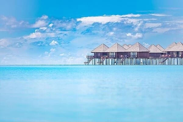 Tropical panorama, luxury water villa resort with wooden pier or jetty. Luxury travel destination background for summer holiday vacation in Maldives