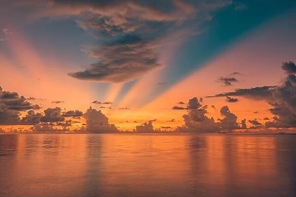Tropical sea sunset, amazing sky reflection over endless ocean water horizon. Tranquil, relaxing seascape, sunrise, rays with clouds, colorful nature