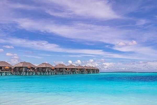 Tropical seascape with water bungalows in the Maldives. Peaceful seaside, stunning beach. Destination for honeymoon and perfect couple vacations