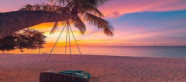 Tropical sunset beach background as summer coast landscape panorama with leisure beach swing on palm, white sand and calm sea beach horizon
