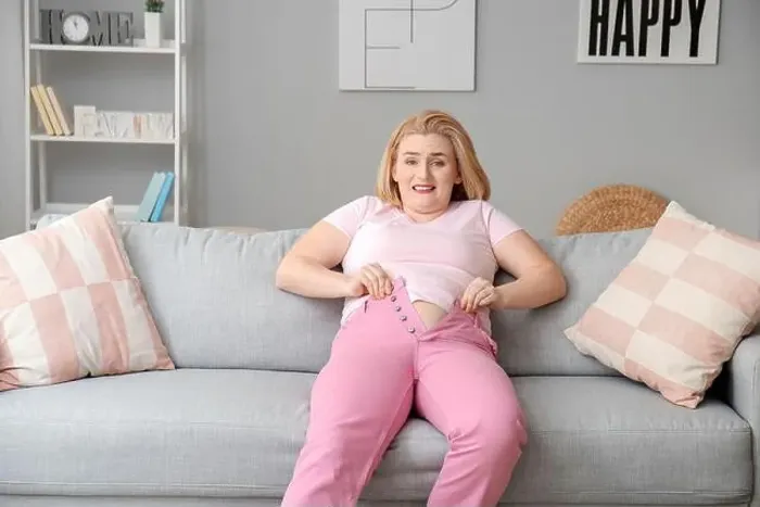Framed Print : Troubled overweight woman in tight clothes at home Framed Print : Troubled overweight woman in tight clothes at home
