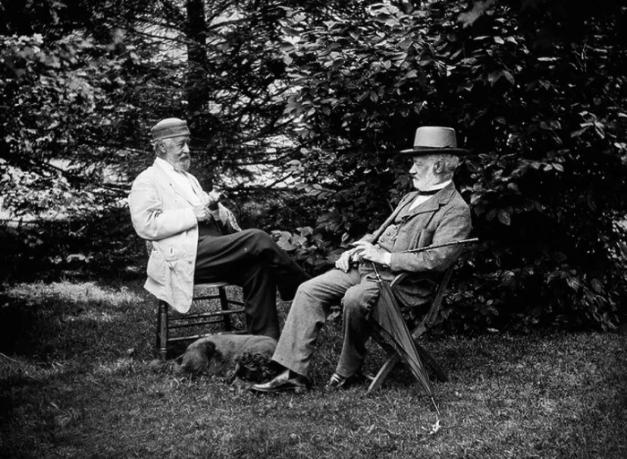 Framed Print : TURN OF THE CENTURY TWO MEN SITTING OUTSIDE IN CHAIRS AMONG TREES SMOKING CIGARS TALKING DOG LAYING AT THEIR FEET Framed Print : TURN OF THE CENTURY TWO MEN SITTING OUTSIDE IN CHAIRS AMONG TREES SMOKING CIGARS TALKING DOG LAYING AT THEIR FEET