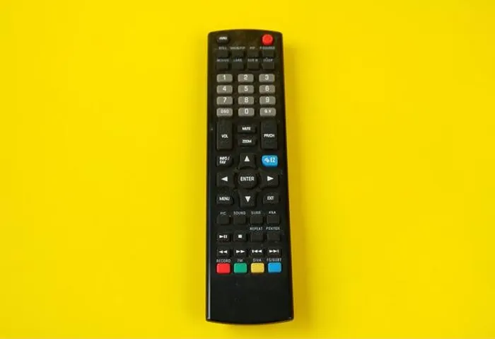 Framed Print : tv remote isolated on yellow background
