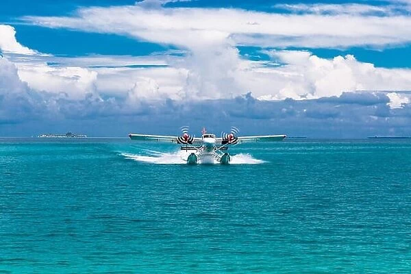 Twin otter red and white seaplane landing at Maldives