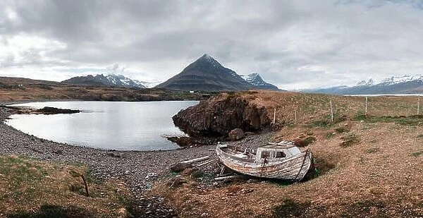 Typical Iceland landscape with fjord, mountains and old ship
