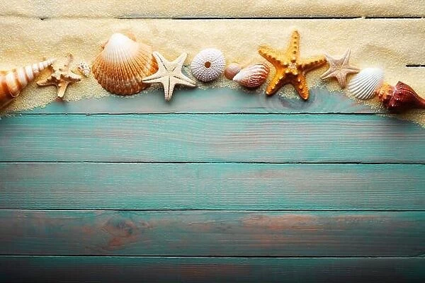Vacations and summer time concept with starfish and sea shells on a turquoise wooden table with sand