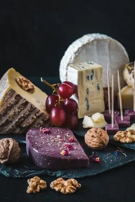 Framed Print : Variety of exclusive and colorful cheese, decorated with red grapes, on black background, vertical Framed Print : Variety of exclusive and colorful cheese, decorated with red grapes, on black background, vertical