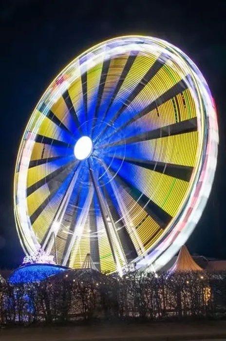 Framed Print : A vertical shot of a Ferris wheel with bright blurry neon lights shining from it at night Framed Print : A vertical shot of a Ferris wheel with bright blurry neon lights shining from it at night