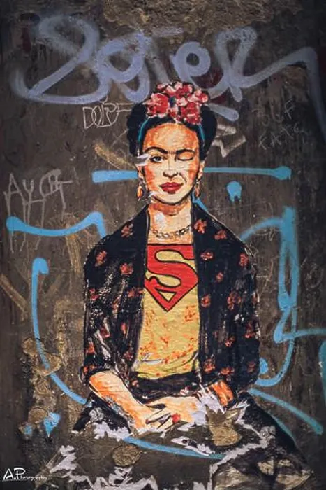 Framed Print : A vertical shot of Frida Kahlo portrait with superman shirt on a wall with graffiti Framed Print : A vertical shot of Frida Kahlo portrait with superman shirt on a wall with graffiti