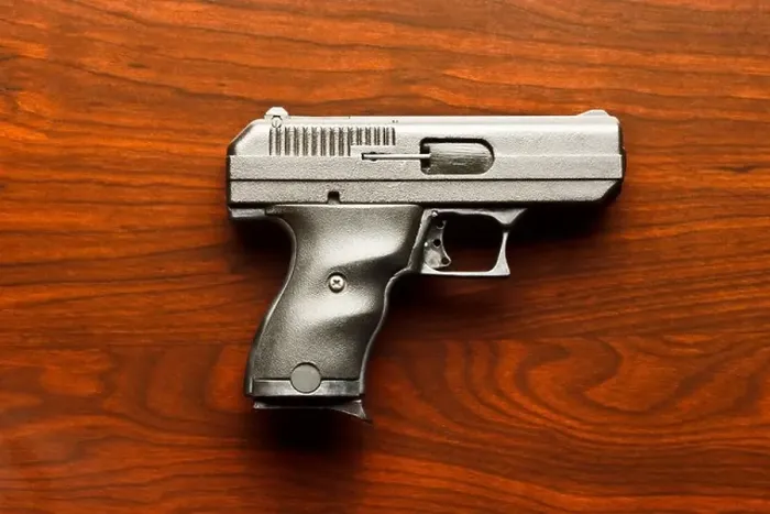 Framed Print : Top view of 9 mm handgun against wooden surface Framed Print : Top view of 9 mm handgun against wooden surface
