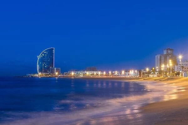 View of Barcelona Beach in summer night along seaside in Barcelona, Spain. Mediterranean Sea in Spain