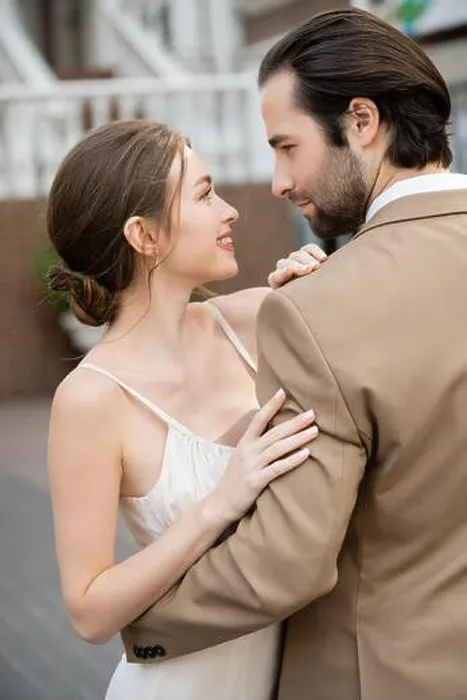 Framed Print : side view of groom in beige suit hugging smiling bride in white wedding dress, stock image Framed Print : side view of groom in beige suit hugging smiling bride in white wedding dress, stock image