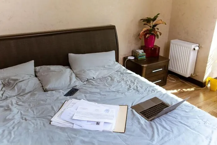 Framed Print : view of laptop with documents on bed. home work concept Framed Print : view of laptop with documents on bed. home work concept