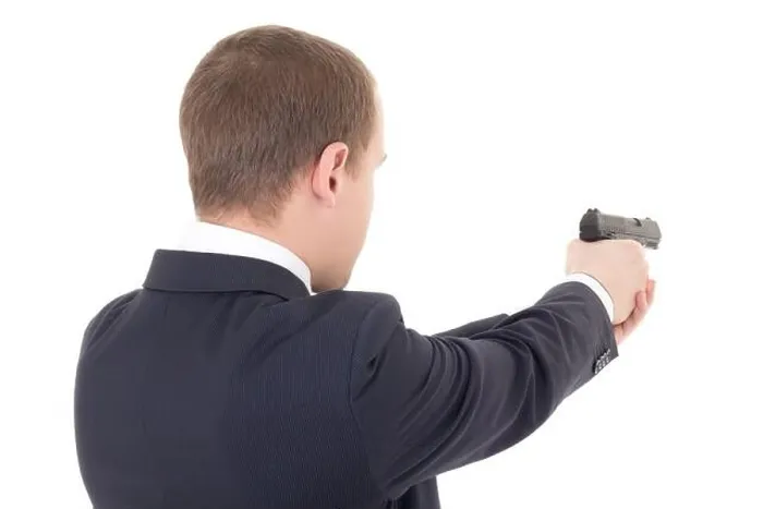 Framed Print : back view of man shooting with gun isolated on white background Framed Print : back view of man shooting with gun isolated on white background