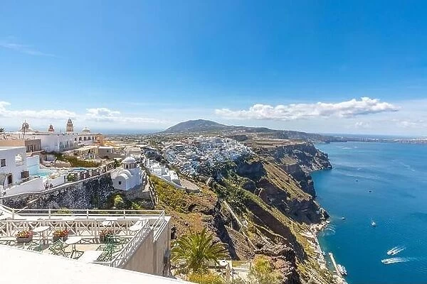 View of the restaurant city of Fira on Sunny summer day. Santorini, Greece. Scenic view traditional cycladic Santorini white houses. Travel landscape