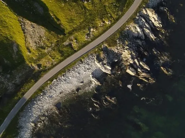 Framed Print : Top down view of a road on a sea shore. Cliffs covered with greenery, rocky shore and a dark blue sea Framed Print : Top down view of a road on a sea shore. Cliffs covered with greenery, rocky shore and a dark blue sea