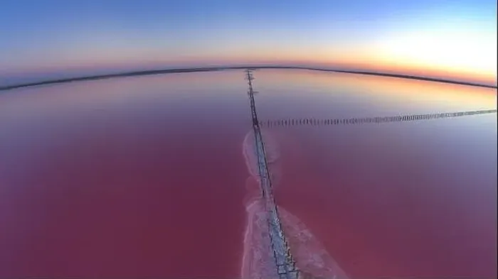 Framed Print : Top view of a shiny salty pink lake and a path along it Framed Print : Top view of a shiny salty pink lake and a path along it